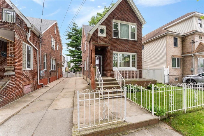 View of front of property featuring brick siding and a fenced front yard