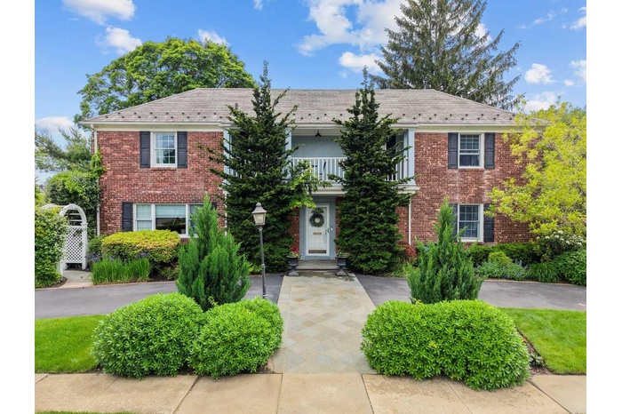 Front view of a beautiful brick Colonial-style house.