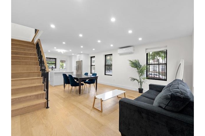 Living room with a wall mounted AC, stairs, recessed lighting, and light wood-style floors