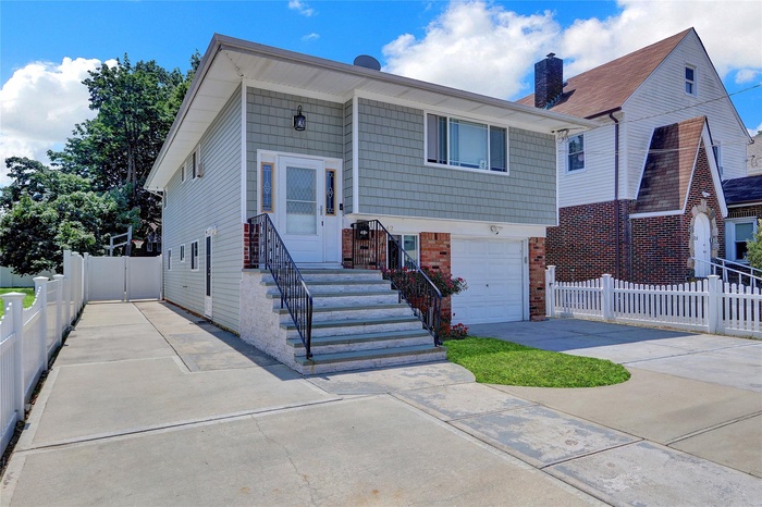 View of front of house with concrete driveway, brick siding, and an attached garage