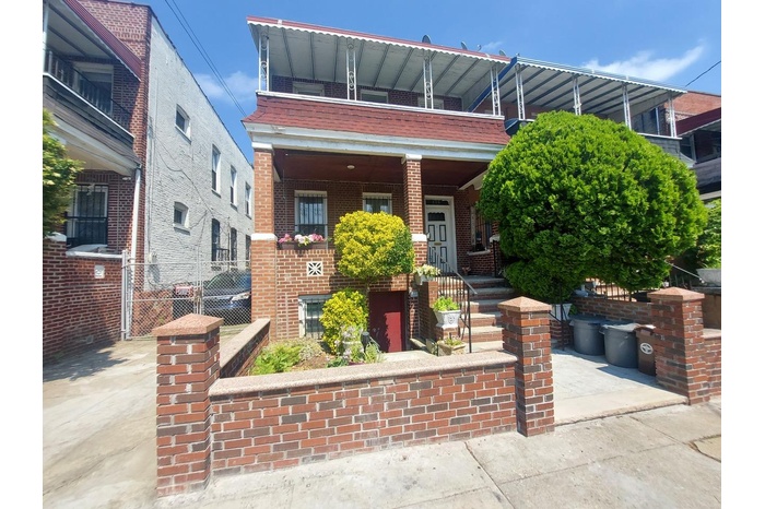 View of front of property featuring brick siding, a balcony, and covered porch