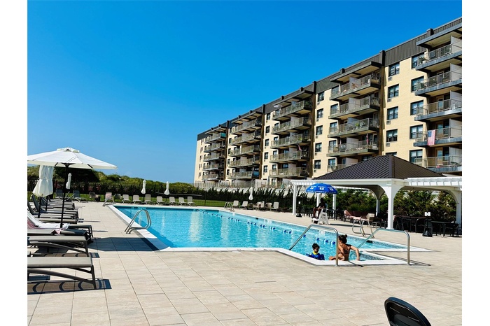 Community pool with a pergola, fence, and a patio area