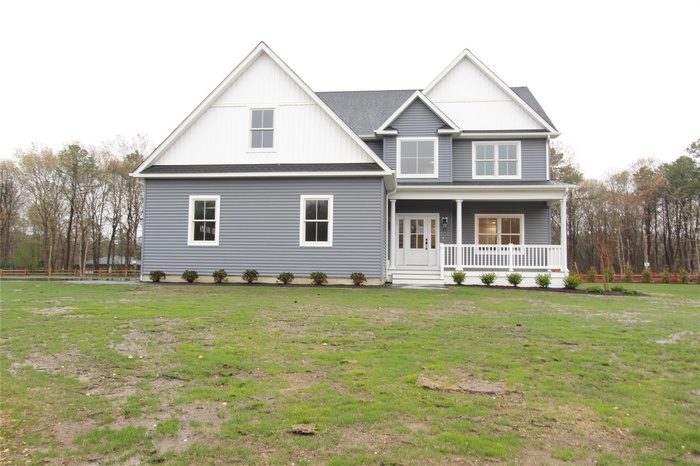 View of front of property with a porch and a front yard