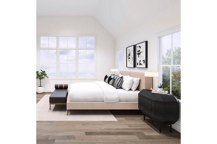 Bedroom featuring wood finished floors, multiple windows, and lofted ceiling