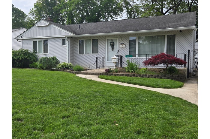 View of front of home featuring a front lawn and a shingled roof