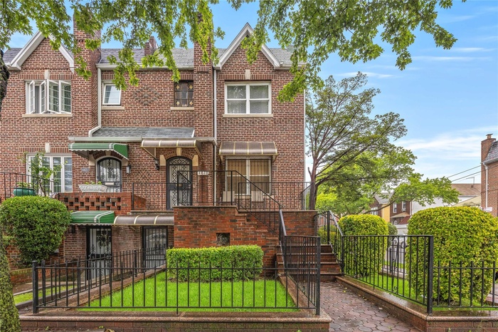 View of front of property featuring brick siding, a fenced front yard, and a shingled roof