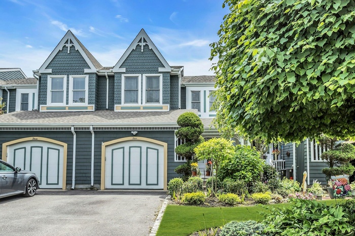 Victorian-style house featuring a shingled roof, asphalt driveway, and an attached garage