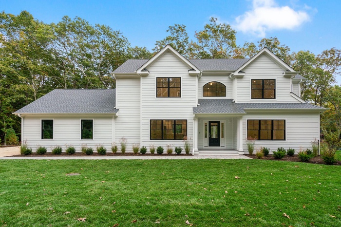 Modern inspired farmhouse featuring roof with shingles and a front yard