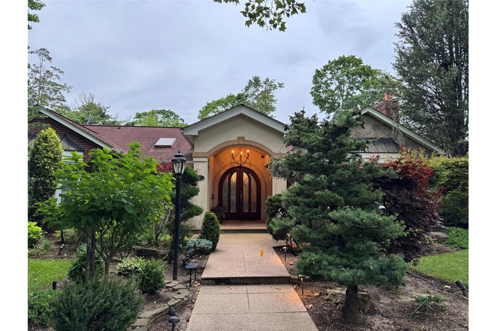 View of front of property with french doors, stucco siding, and a chimney