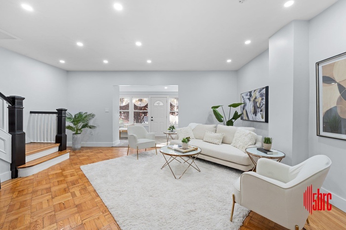 Living area with recessed lighting and stairway