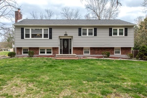 Set back from the road, buffered by a row of mature trees, sits this handsome, spacious home.