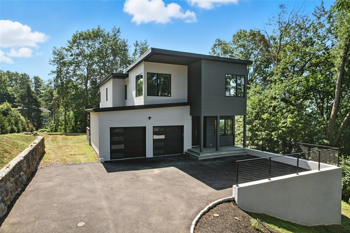 Front property with asphalt driveway, a garage, and stucco siding