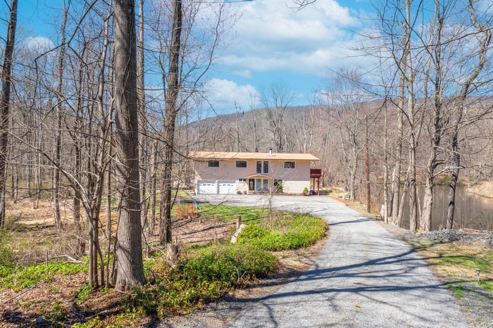 View of front of house with a mountain view, a garage, and driveway