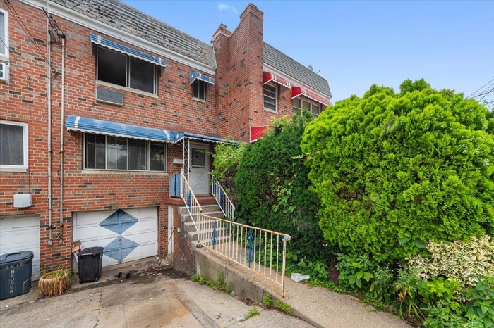 View of building exterior with driveway and an attached garage