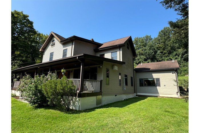 Back of house featuring a lawn and a porch