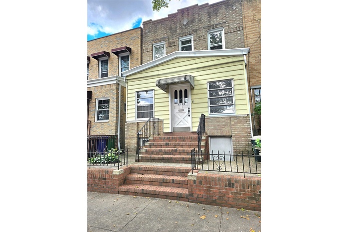 View of front facade with a fenced front yard and brick siding