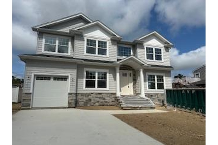 Craftsman inspired home featuring driveway, an attached garage, and stone siding