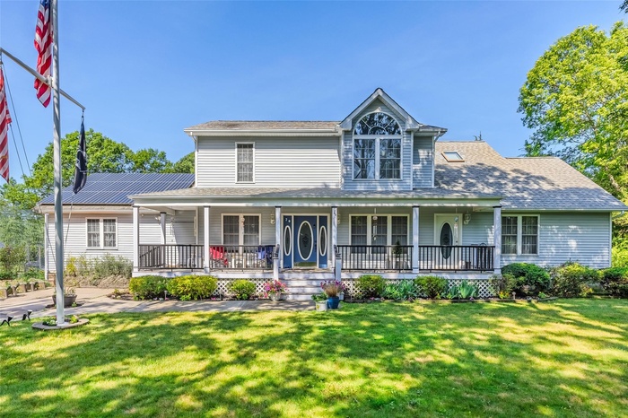 Farmhouse with a front yard and a porch