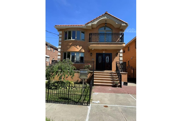 Mediterranean / spanish-style house featuring a balcony, a fenced front yard, brick siding, covered porch, and a tiled roof