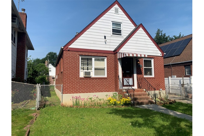 View of front of house with brick siding, a gate, and cooling unit