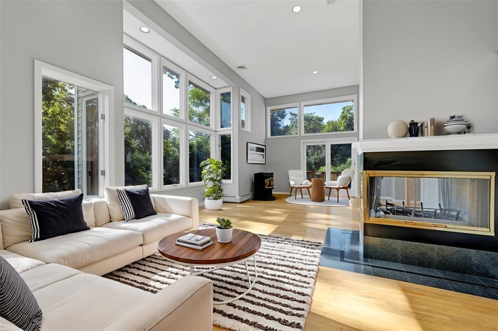 Living room with wood finished floors, recessed lighting, and a high ceiling