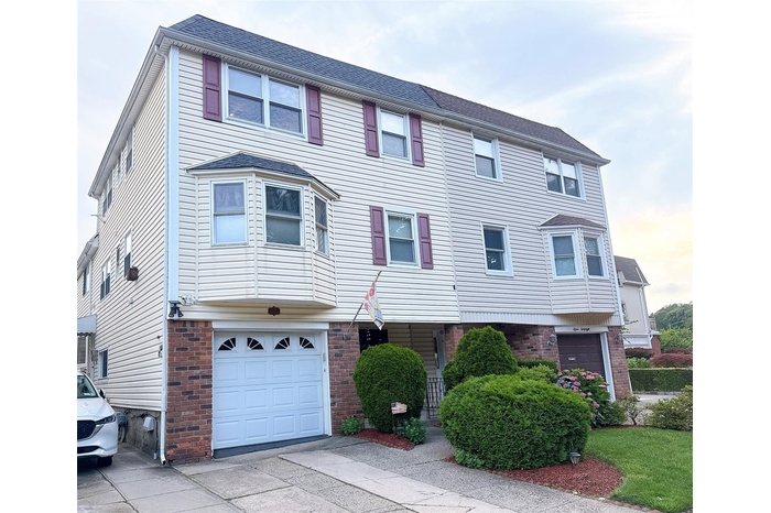 View of front of property with an attached garage, brick siding, and concrete driveway