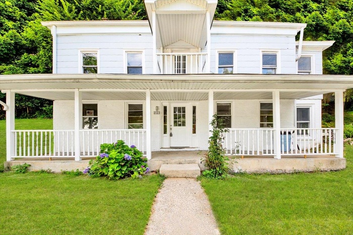 View of front of home with covered porch and a front lawn