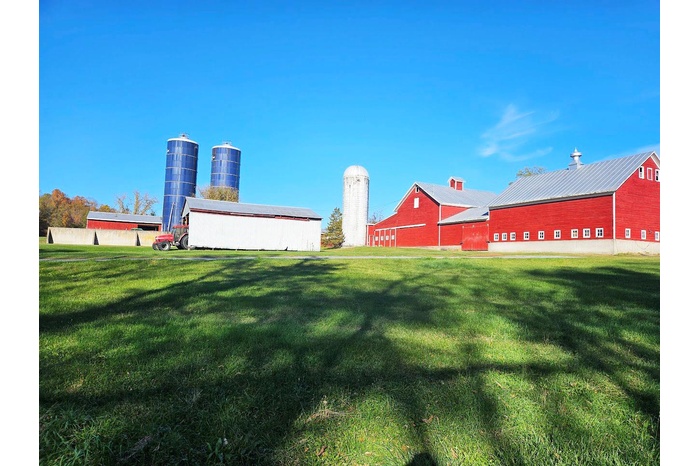 View of farm featuring barns, silos and a pole building