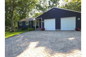 Enter into the living room area featuring Cathedral Ceilings, with an open floor plan to the kitchen and dining area.