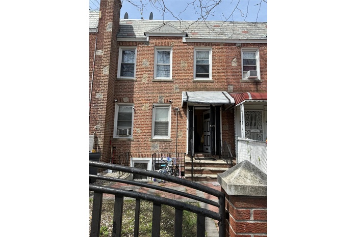 Back of property with brick siding and cooling unit