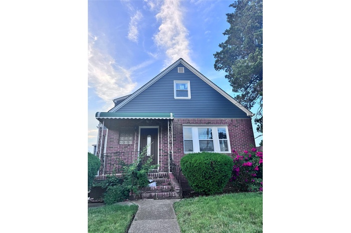 View of front of house featuring brick siding and a porch