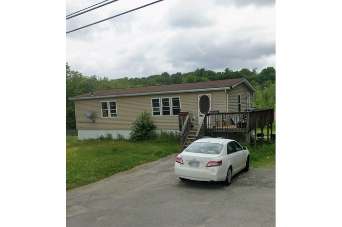 Manufactured / mobile home featuring a deck and a front lawn