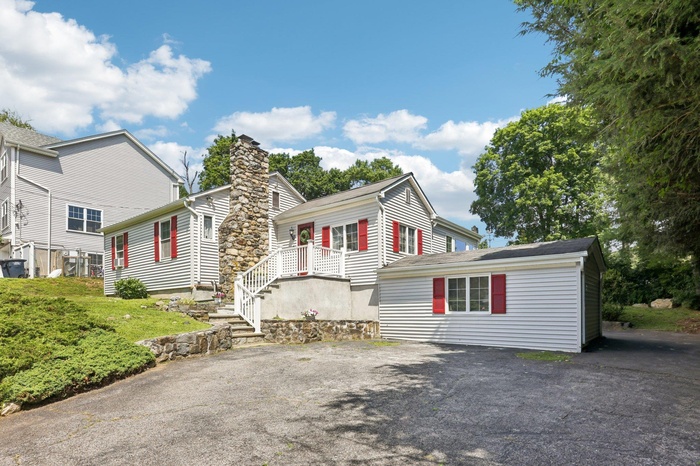 View of front of property with driveway and a chimney