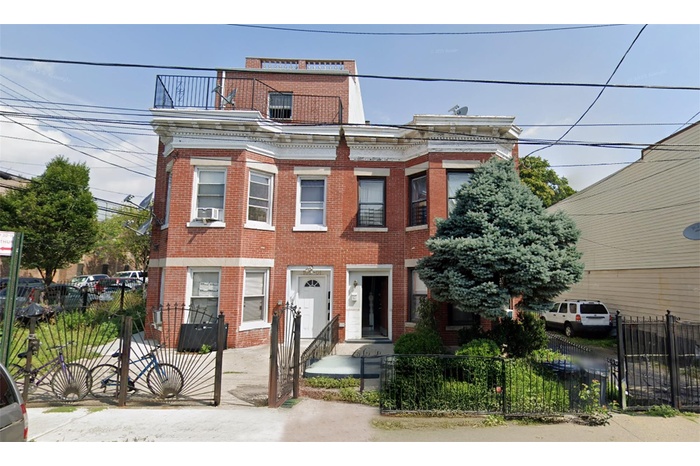 View of front of house featuring brick siding and a fenced front yard