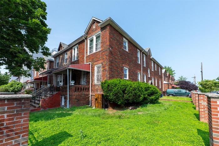 View of property exterior featuring brick siding and a yard