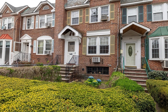 View of property with brick siding, fence private yard, entry steps, and cooling unit