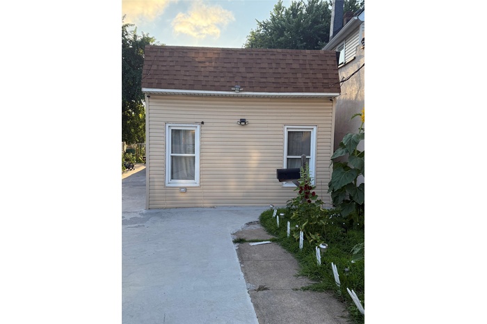 View of property exterior featuring roof with shingles and a patio area