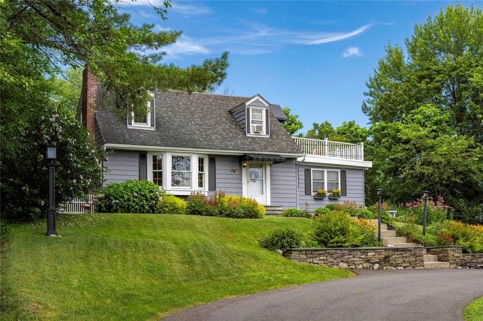 Cape cod-style house with beautiful flower gardens