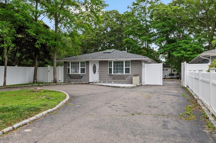 View of front of home with a shingled roof and driveway