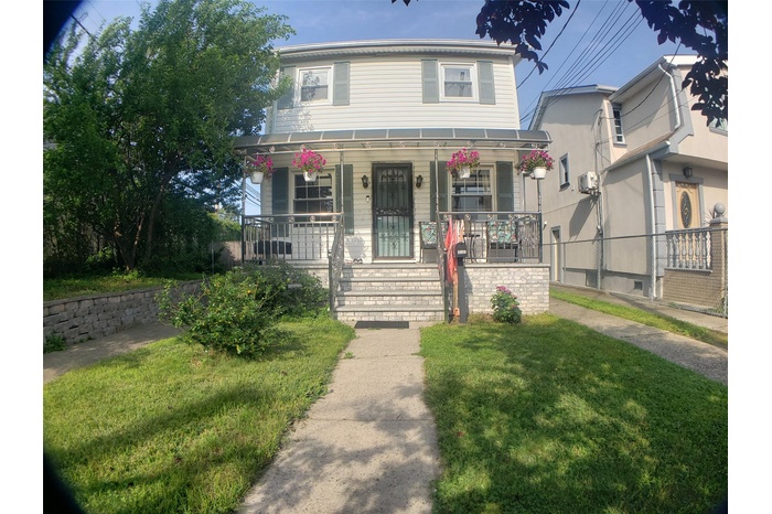View of house with covered porch  & yard.