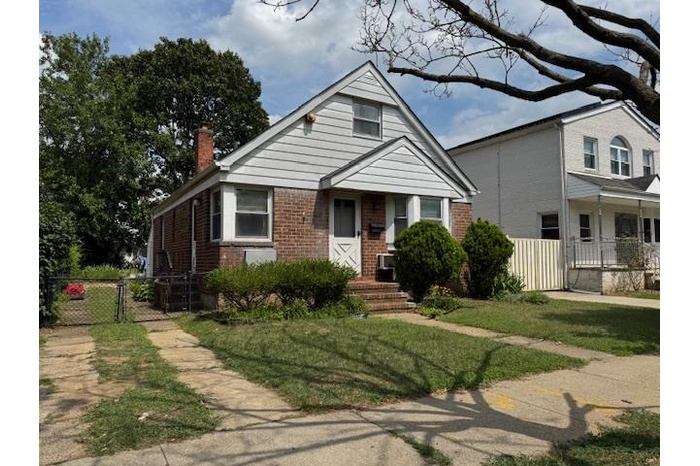 Bungalow featuring brick siding, a gate, a chimney, and covered porch
