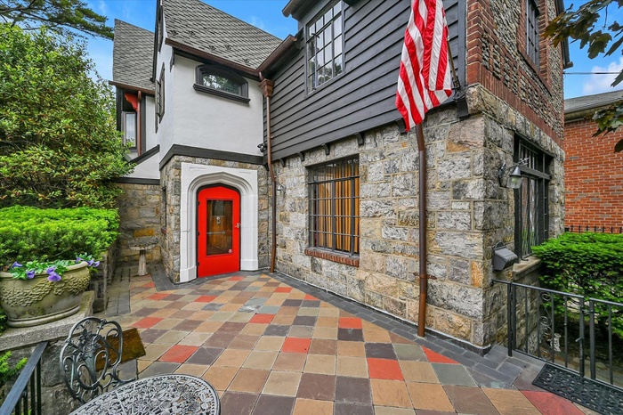Entrance to property featuring stone siding, stucco siding, and a patio area
