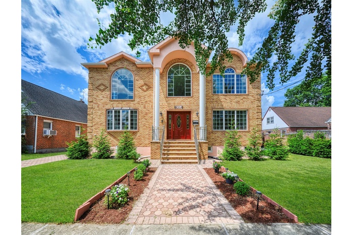 Traditional-style house featuring brick siding, a front yard, and cooling unit