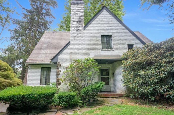 View of front of property with brick siding and a chimney