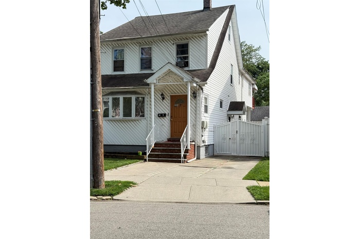 View of front of home with a chimney, roof with shingles, a gate, and entry steps