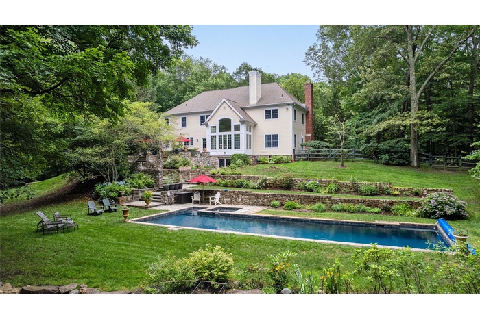 The private and inviting back yard is all  fenced and beautifully landscaped with specimen trees, hydrangeas, amazing stonewalls, stone patio & terrac