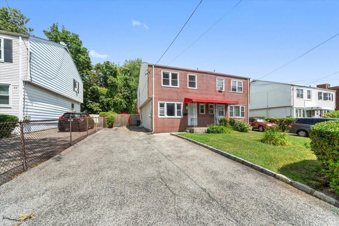 View of property with brick siding and driveway
