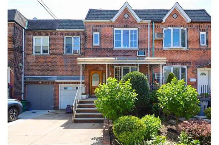Townhome / multi-family property featuring brick siding, concrete driveway, and a high end roof