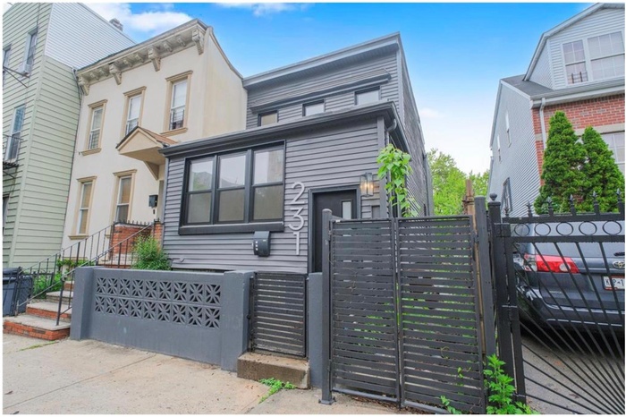 View of front facade with a gate, a fenced front yard, and stucco siding