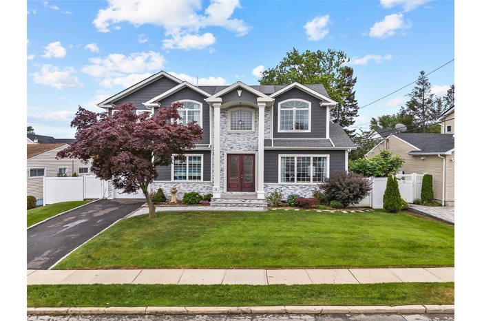 Traditional-style house featuring french doors, stone siding, driveway, and a garage